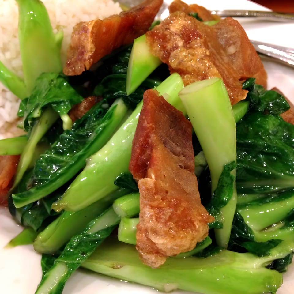 Close-up of Boran Thai Restaurant's crispy pork belly with stir-fried Chinese broccoli and rice.