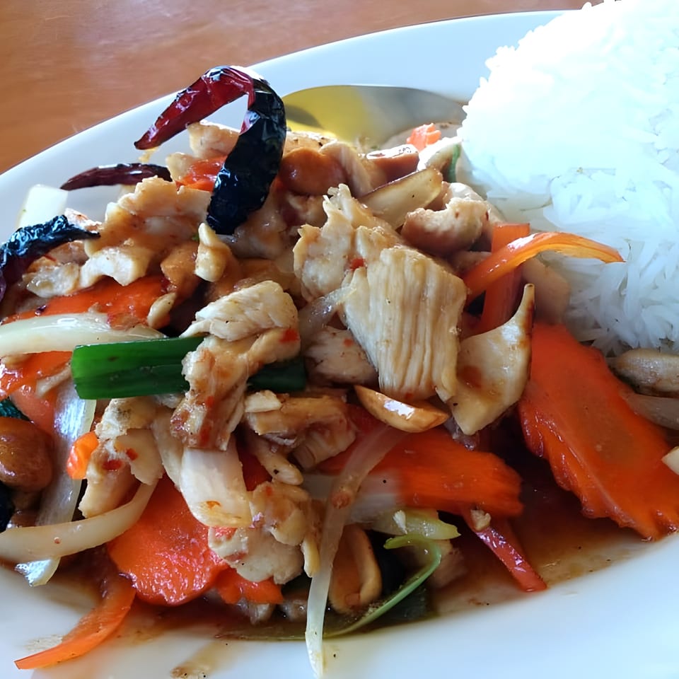 Boran Thai Restaurant's stir-fried chicken with vegetables, cashews, and dried chilies, served with white rice.